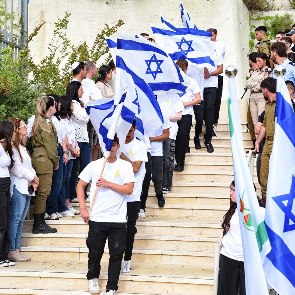 תלמידים צועדים עם דגלי ישראל